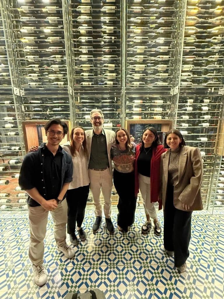 Community members together in front of a brightly lit building interior.