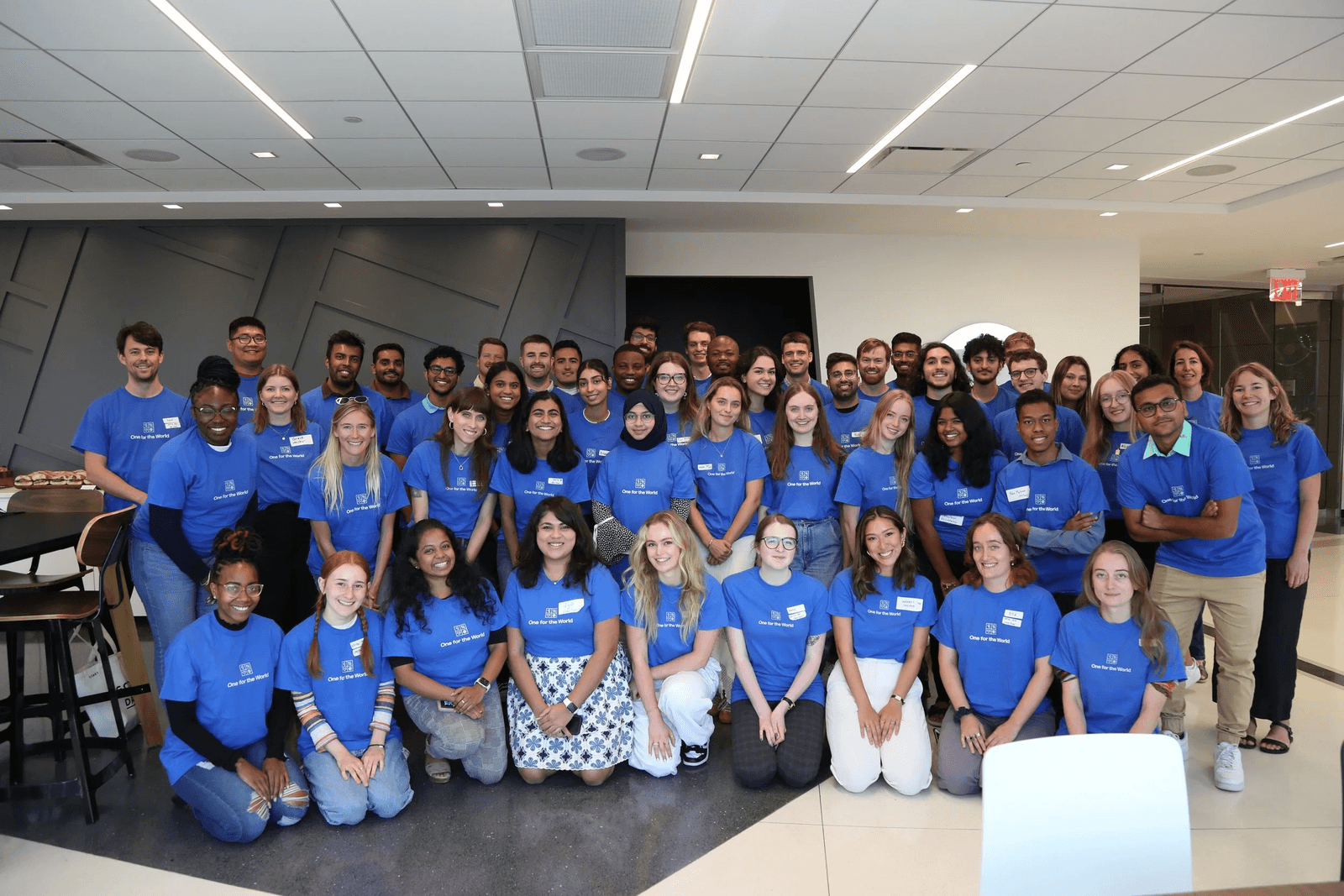 One for the World community members wearing blue shirts pose for a group photo.